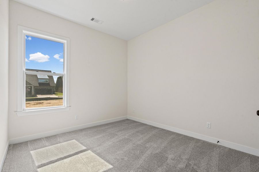 Empty room with light colored carpet and baseboards