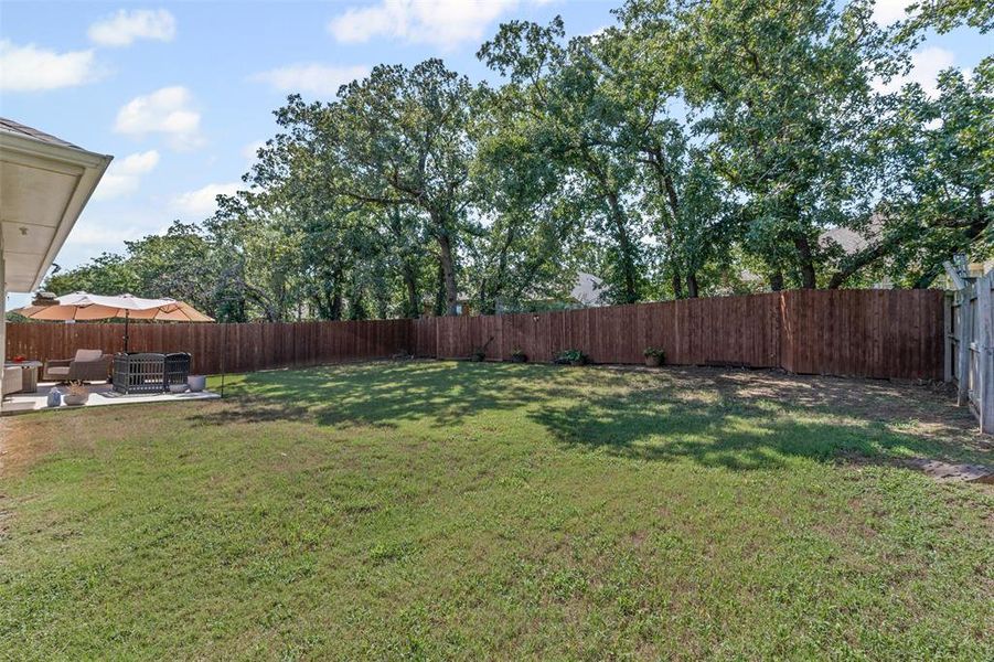 Fenced backyard with a patio and an outdoor hangout area Fenced backyard with a patio and an outdoor hangout area