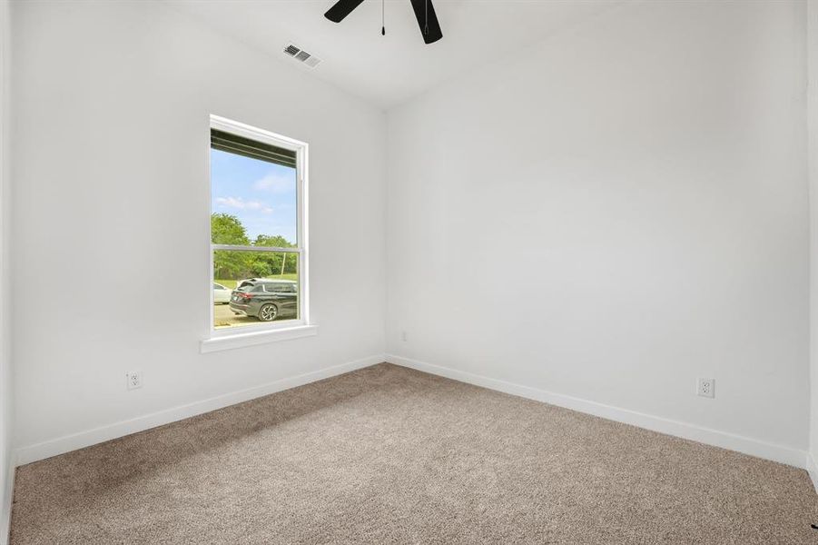 Carpeted empty room with ceiling fan