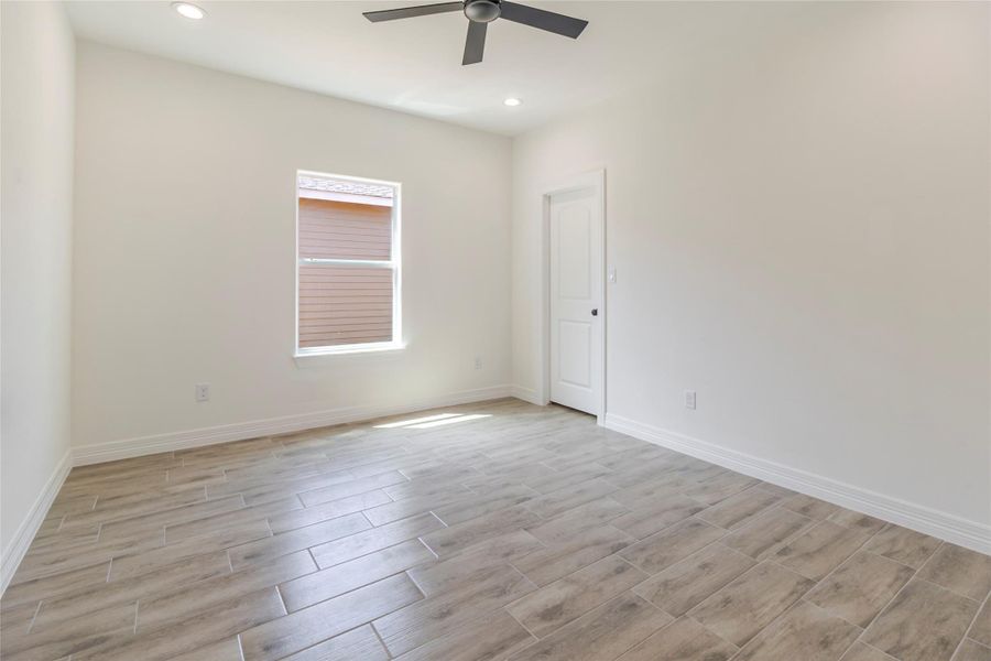 The first secondary bedroom keeps things straightforward with a window, ceiling fan, and walk-in closet of its own. The first secondary bedroom keeps things straightforward with a window, ceiling fan, and walk-in closet of its own.