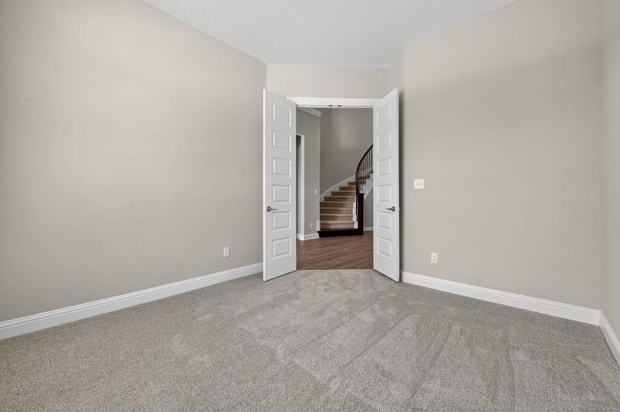 Empty room featuring light carpet and stairway