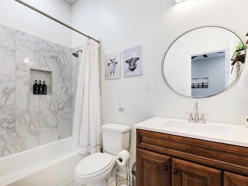 Bathroom with shower / bath combo with shower curtain and vanity