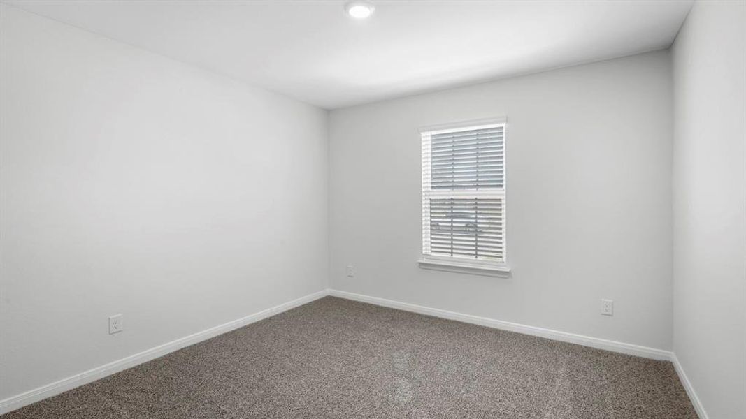 Unfurnished room with baseboards and dark colored carpet