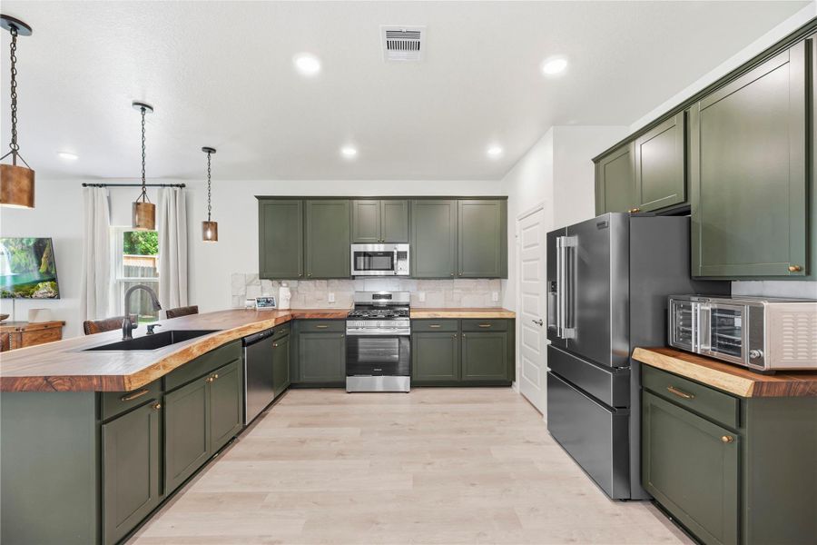 Absolutely incredible kitchen features upgraded countertops imported from Brazil, striking stone backsplash, stylish hunter green cabinetry and stainless steel appliances. Absolutely incredible kitchen features upgraded countertops imported from Brazil, striking stone backsplash, stylish hunter green cabinetry and stainless steel appliances.