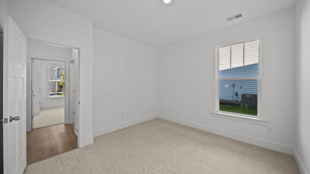 Accomplished design in this restful bedroom featuring plush carpet and oversized window views