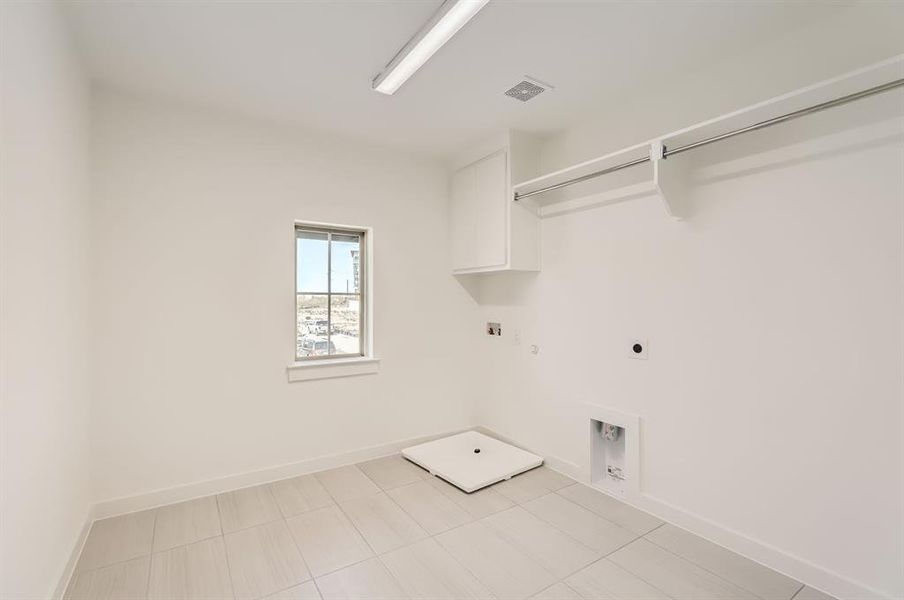 Laundry room with washer hookup, electric dryer hookup, hookup for a gas dryer, and light tile patterned floors