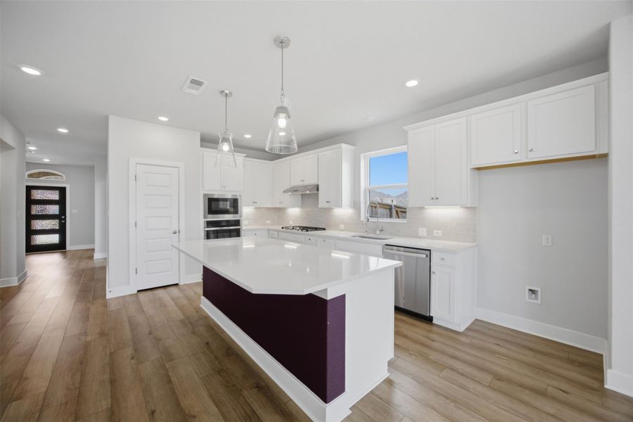 A well-appointed kitchen showcasing a spacious island and gleaming stainless steel appliances.