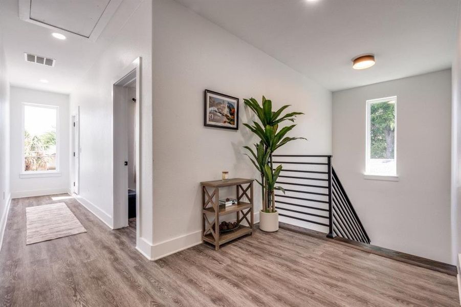 Hallway featuring wood finished floors, an upstairs landing, recessed lighting, and attic access