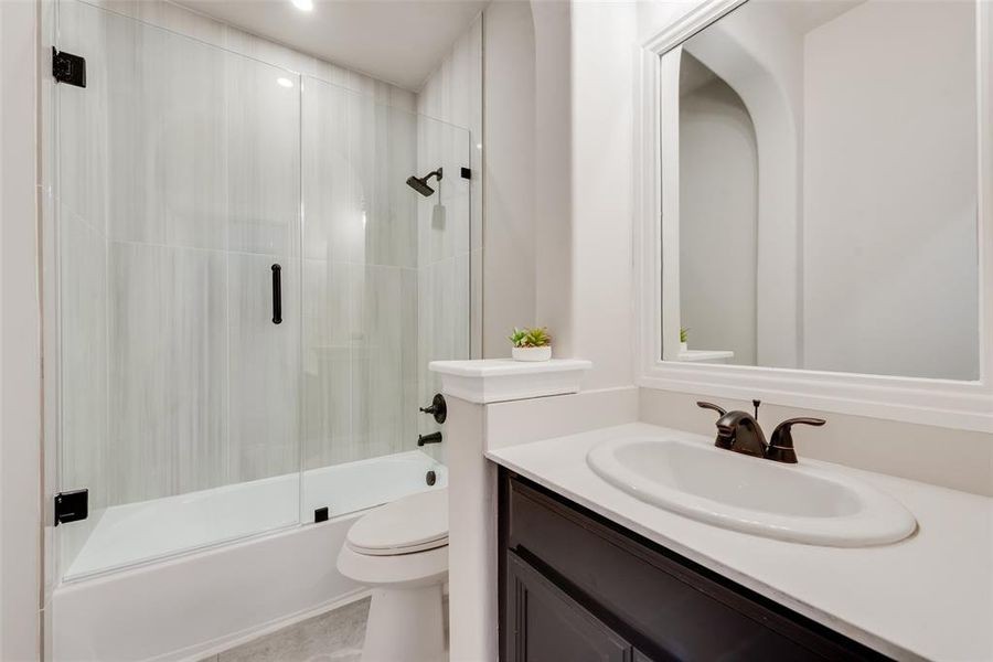 Bathroom with combined bath / shower with glass door, vanity, and recessed lighting Bathroom with combined bath / shower with glass door, vanity, and recessed lighting