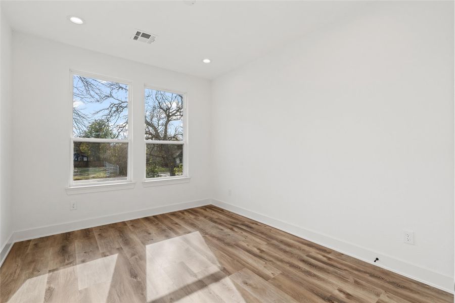 Bright secondary bedroom with modern flooring, clean finishes, and great natural light.