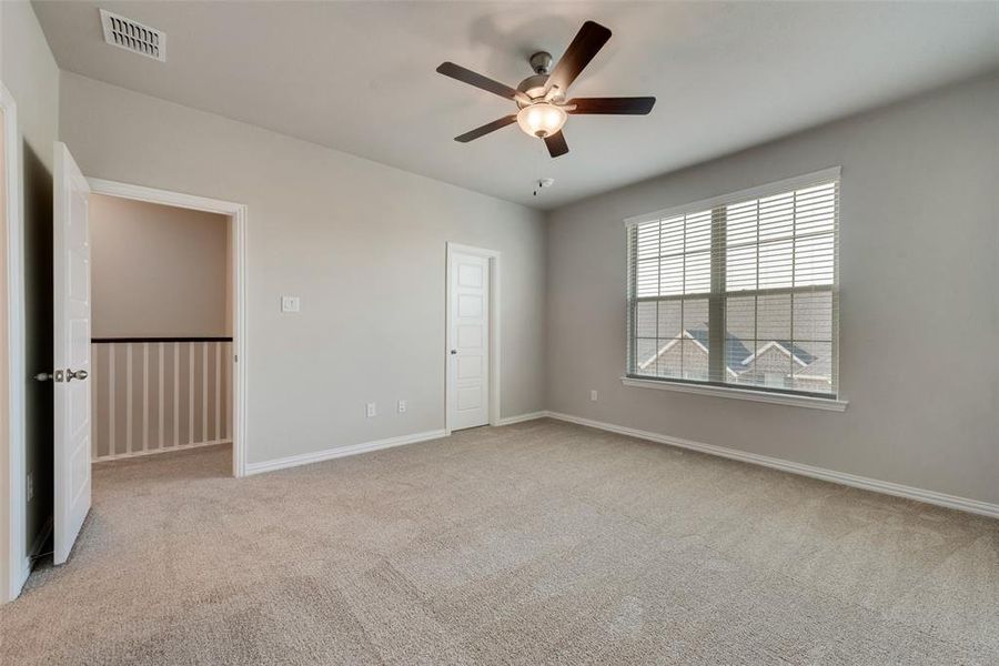 Unfurnished bedroom with light colored carpet and ceiling fan