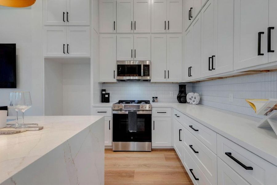 Elegant quartz island with overflow, soft-close drawers, and genuine tile backsplash.