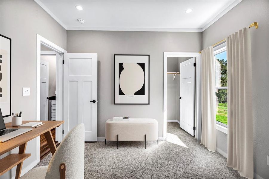 Carpeted bedroom featuring a walk in closet, a desk, and ornamental molding