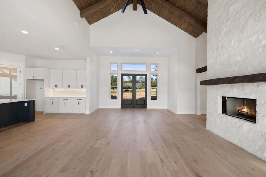 A spacious living area features a warm fireplace, abundant natural light, and impressive vaulted beamed ceilings. A spacious living area features a warm fireplace, abundant natural light, and impressive vaulted beamed ceilings.