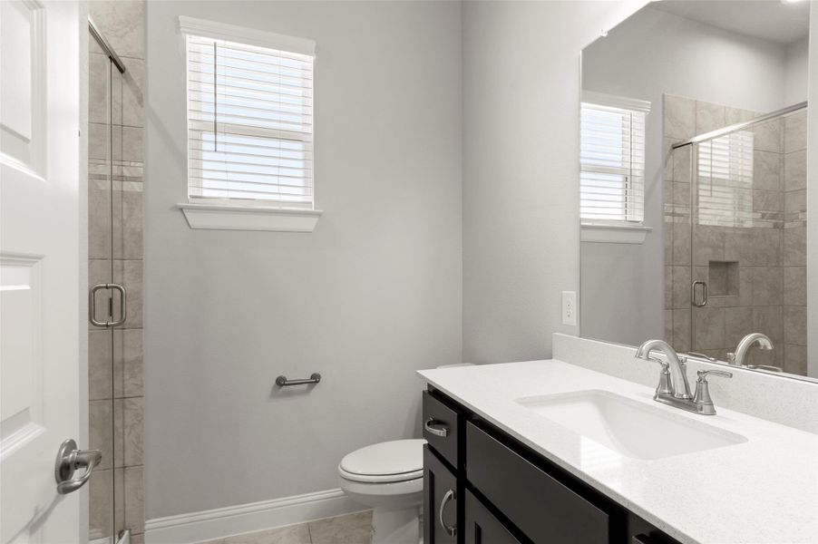 Full bath with vanity, a stall shower, and tile patterned floors Full bath with vanity, a stall shower, and tile patterned floors
