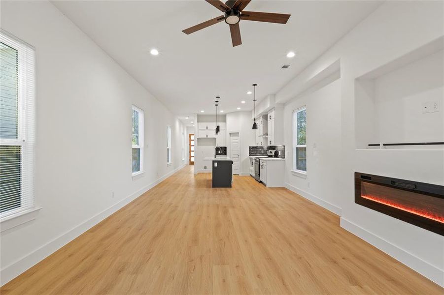 Unfurnished living room featuring ceiling fan and light hardwood / wood-style floors