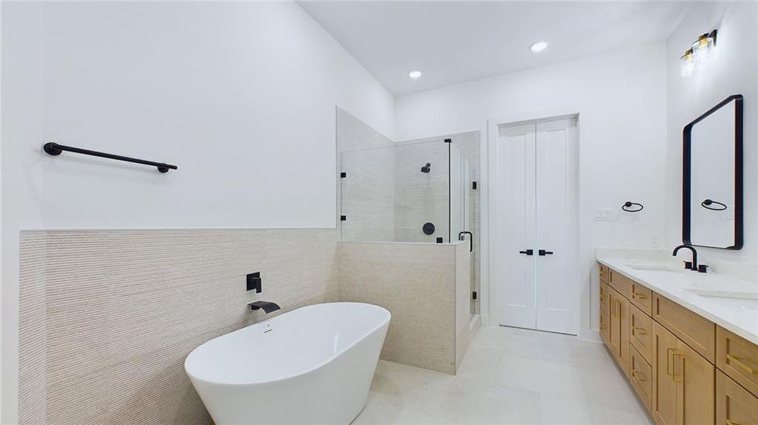 Primary bathroom boasts his and hers vanities, a private water closet, a glass-enclosed walk in shower, with an incredible soaking tub.