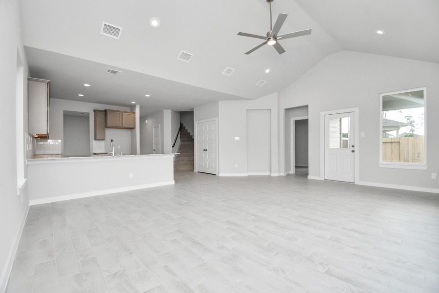 Gather the family and guests together in your lovely living room! Featuring soaring high ceilings, recessed lighting, ceiling fan, custom paint, gorgeous floors, and large windows that provide plenty of natural lighting throughout the day. Sample photo of completed home with similar floor plan. Actual colors and selections may vary.