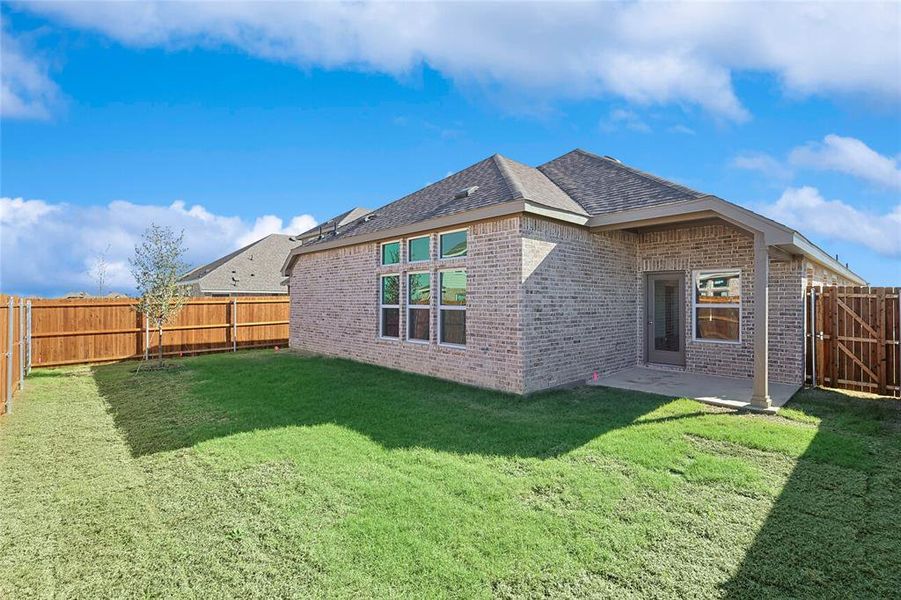 Back of house with a yard and a patio area