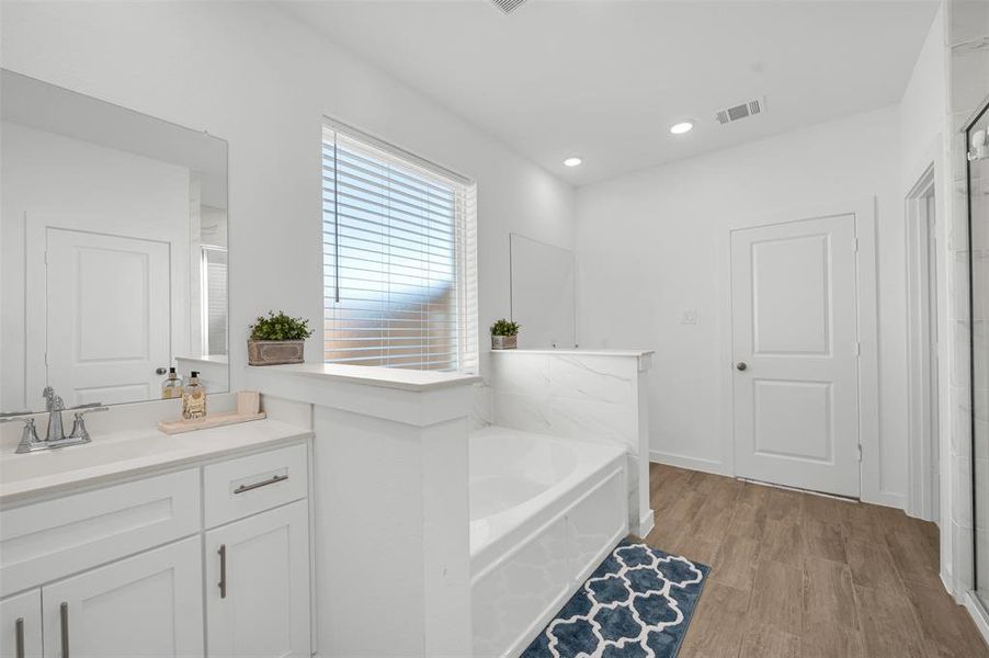 Bathroom featuring vanity, hardwood / wood-style floors, and a bathing tub