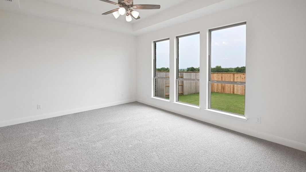 Empty room with baseboards, a ceiling fan, and carpet