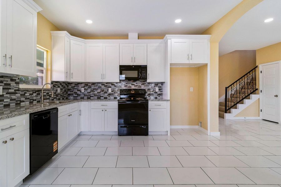 Kitchen, half bath Powder room with some storage area inside and direction to upstairs, primary and carport access. Kitchen, half bath Powder room with some storage area inside and direction to upstairs, primary and carport access.