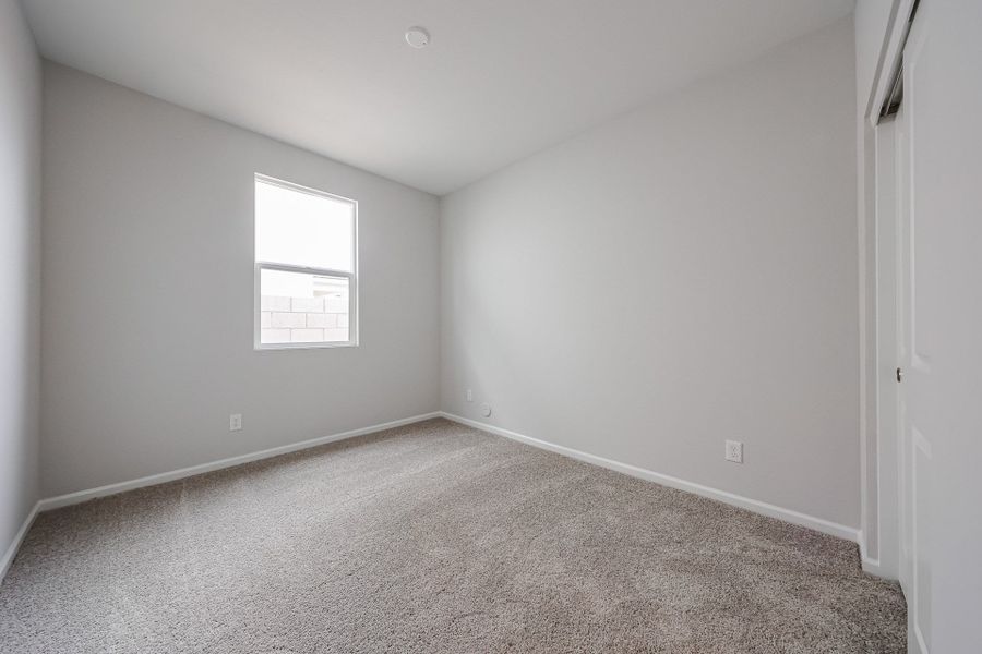 A room with a carpet and a window.