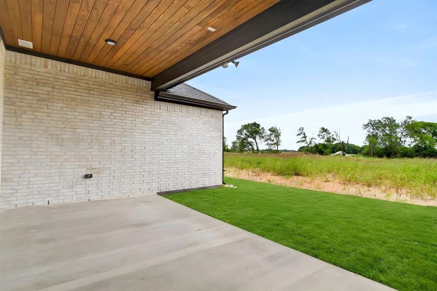 Covered patio with a wood-finish ceiling, integrated recessed lighting, and a light-colored brick exterior Covered patio with a wood-finish ceiling, integrated recessed lighting, and a light-colored brick exterior
