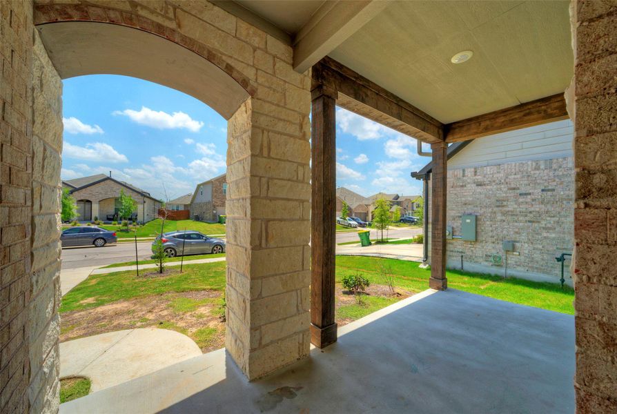 A welcoming stone archway frames the entry to a covered porch, offering pleasant neighborhood views. A welcoming stone archway frames the entry to a covered porch, offering pleasant neighborhood views.