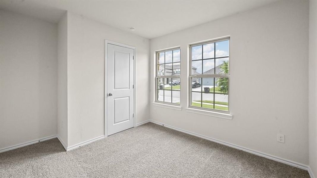 Unfurnished bedroom with light carpet and baseboards