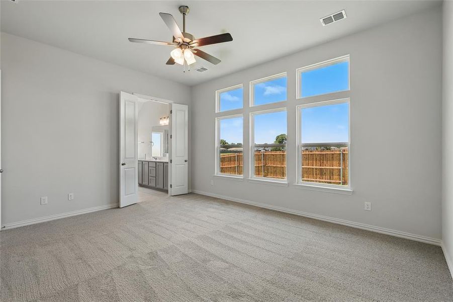 Unfurnished bedroom featuring light carpet, baseboards, ensuite bath, and a ceiling fan Unfurnished bedroom featuring light carpet, baseboards, ensuite bath, and a ceiling fan