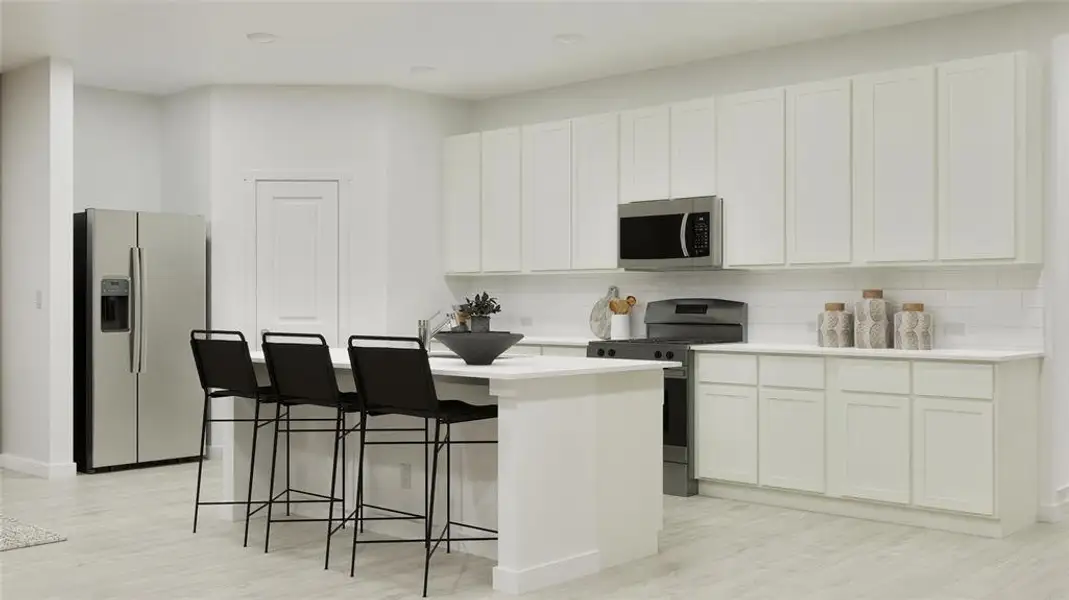 Kitchen featuring appliances with stainless steel finishes, backsplash, a center island with sink, a kitchen breakfast bar, and light wood finished floors