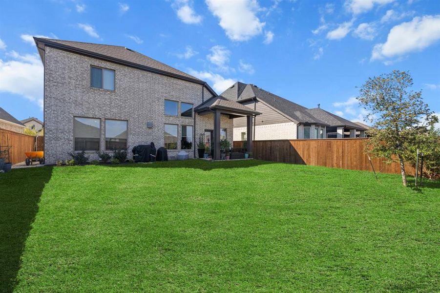 Back of property with a fenced backyard, a patio, and brick siding Back of property with a fenced backyard, a patio, and brick siding