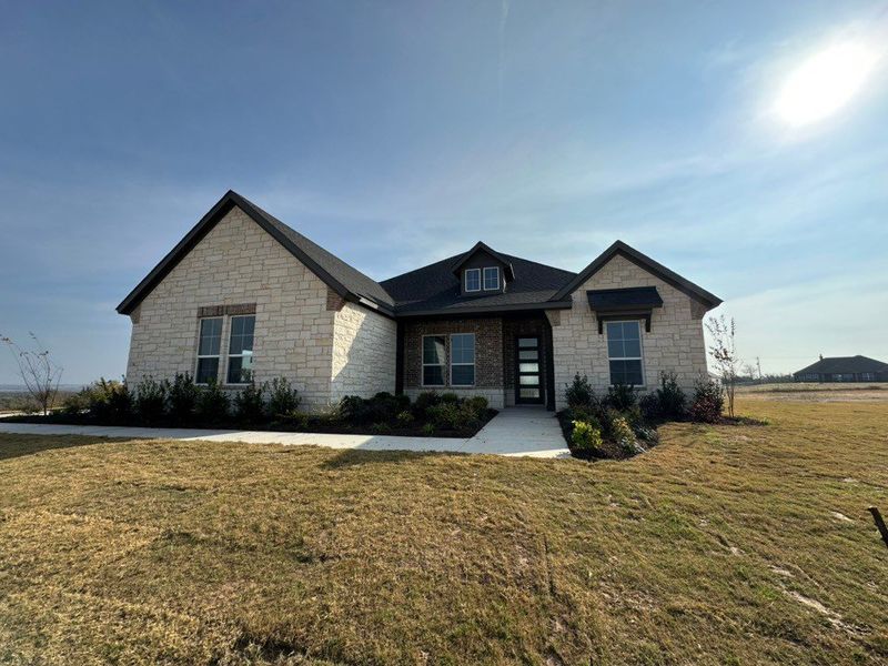 Front exterior of a new home in Eagle Ridge Estates, Weatherford, TX, highlighting curb appeal (Image 1).