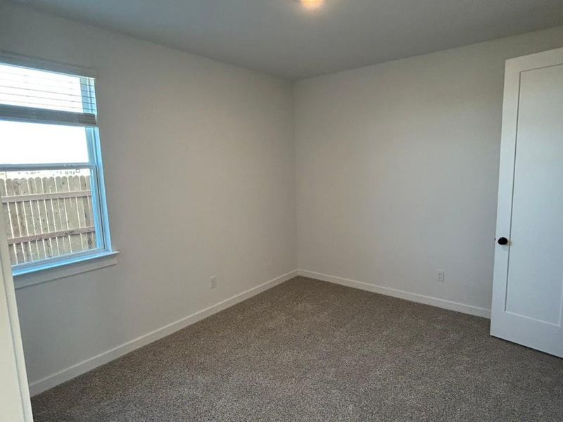 Carpeted spare room featuring baseboards Carpeted spare room featuring baseboards