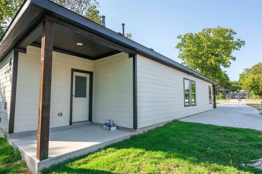 Rear view of house with a patio and a lawn