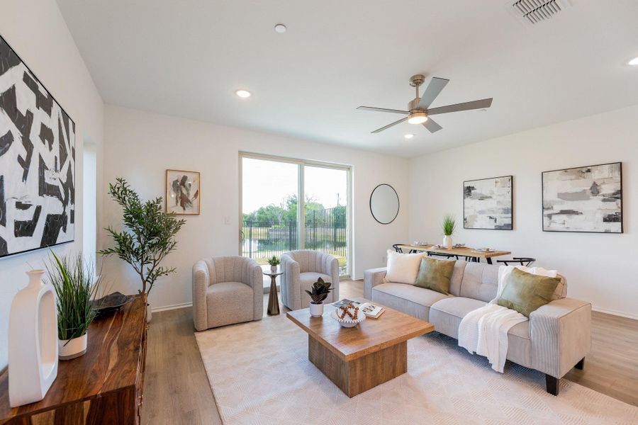 Living room with light wood-type flooring, a ceiling fan, and recessed lighting
