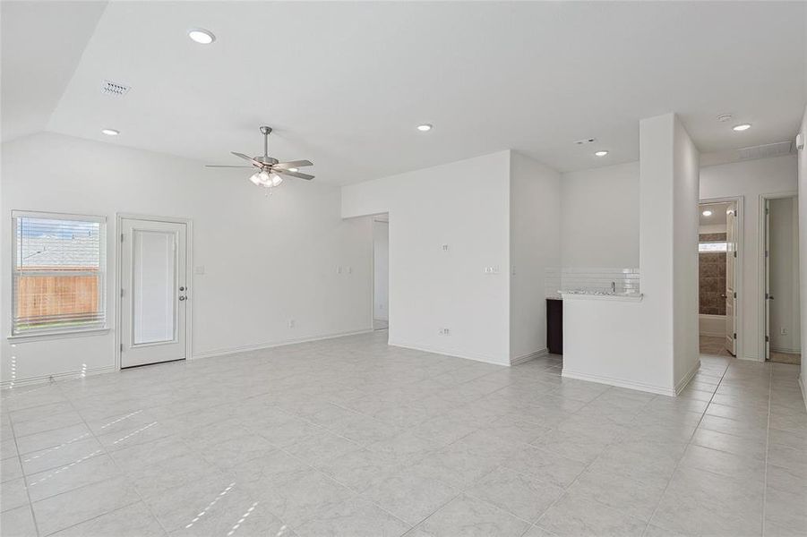 Tiled spare room featuring ceiling fan