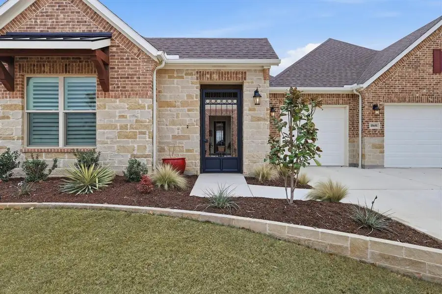 Enter through an Elegant Wrought Iron Gate into a Private Courtyard featuring Four Carriage Lights, Warm Ambiance, and a Welcoming Sitting Area