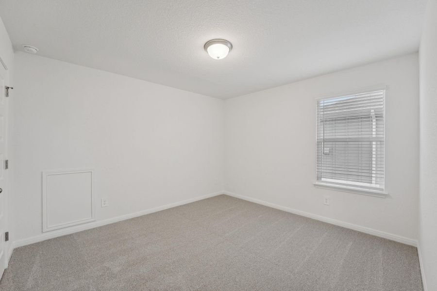 Empty room featuring light carpet and a textured ceiling