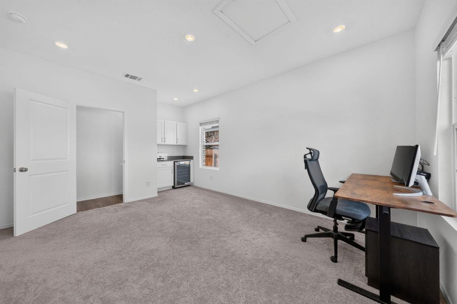 A versatile space features plush carpeting, recessed lighting, and a convenient kitchenette. A versatile space features plush carpeting, recessed lighting, and a convenient kitchenette.