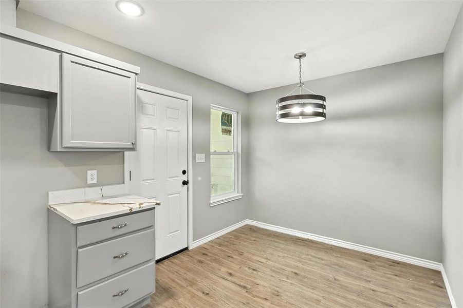 Unfurnished dining area with baseboards and light wood finished floors Unfurnished dining area with baseboards and light wood finished floors