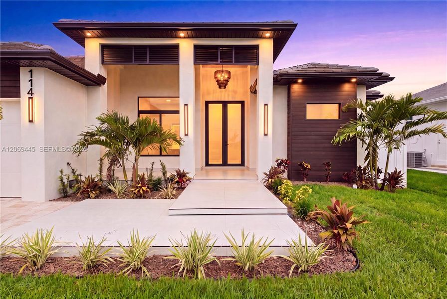 Elegant front elevation, designer landscaping, paver driveway, 3-car garage & striking covered entry w/ soaring columns, modern lighting & frosted double glass doors. Elegant front elevation, designer landscaping, paver driveway, 3-car garage & striking covered entry w/ soaring columns, modern lighting & frosted double glass doors.