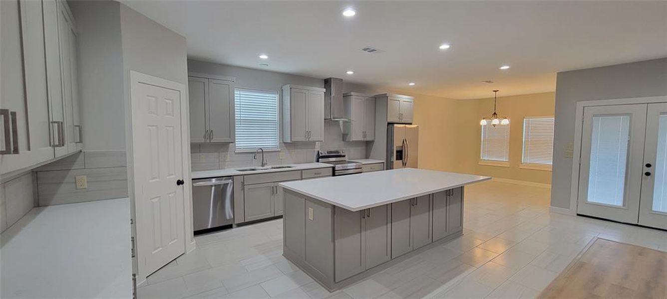 Kitchen featuring a center island, stainless steel appliances, sink, and gray cabinets