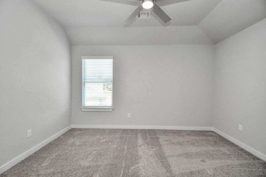 Secondary bedroom features plush carpeting, large windows that let in plenty of natural light, bright paint, and spacious closets. Sample photo of completed home with similar floor plan. Actual colors and selections may vary.
