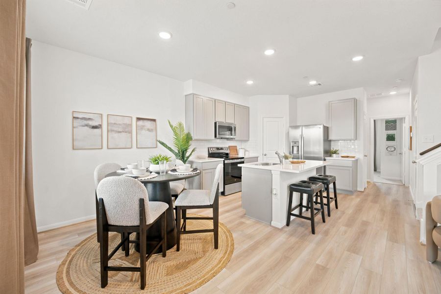 Gleaming wood floors anchor a fluid layout linking the dining area and kitchen.