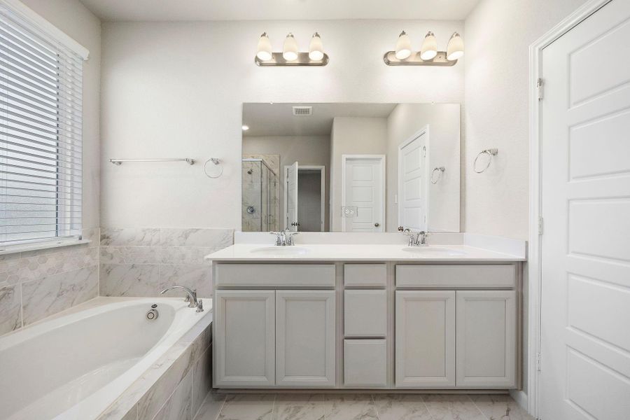 An en-suite bathroom features modern fixtures and a spa-like feel, providing a luxurious escape.