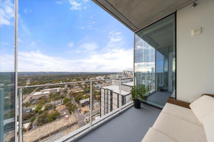 Private terrace with unobstructed views stretching across downtown and the Hill Country, accessed directly from the living area.