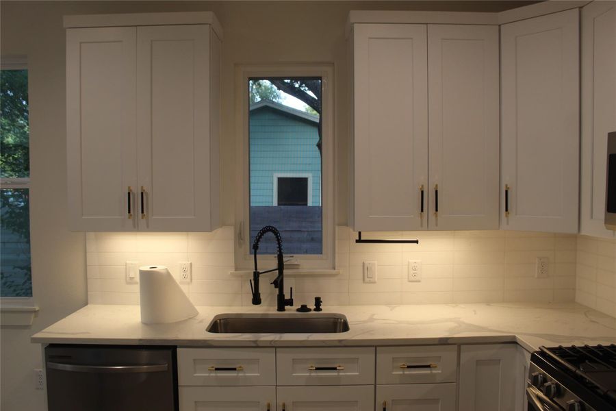 A well-lit kitchen with sleek cabinetry and a sophisticated sink.