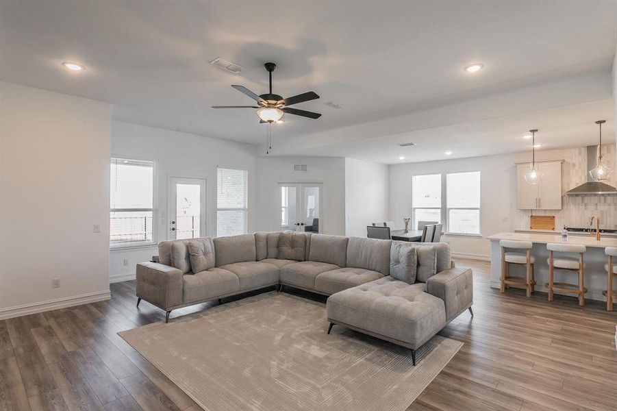 Living room with ceiling fan, dark hardwood / wood-style flooring, french doors, and sink